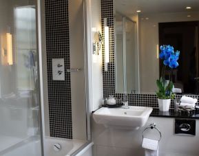 Guest bathroom with combined shower and tub at The Wellington by Blue Orchid Hotel (FKA The Rochester).