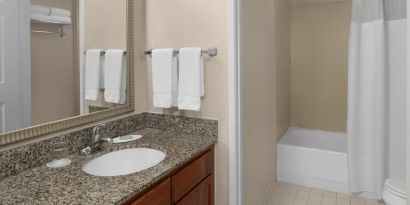 Guest bathroom with shower and tub at Residence Inn By Marriott San Diego Downtown.