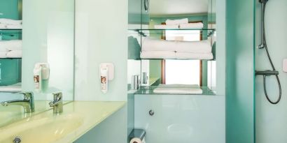 Guest bathroom with shower and free toiletries at ibis Styles Birmingham NEC.