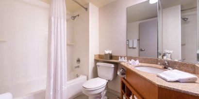 Guest bathroom with shower and tub at Fairfield Inn By Marriott Las Vegas Convention Center.
