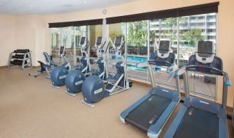 Fitness facility with a view of the pool at Hilton Garden Inn Burbank Downtown.