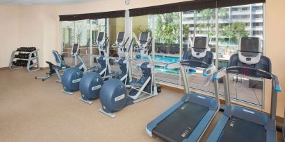 Fitness facility with a view of the pool at Hilton Garden Inn Burbank Downtown.