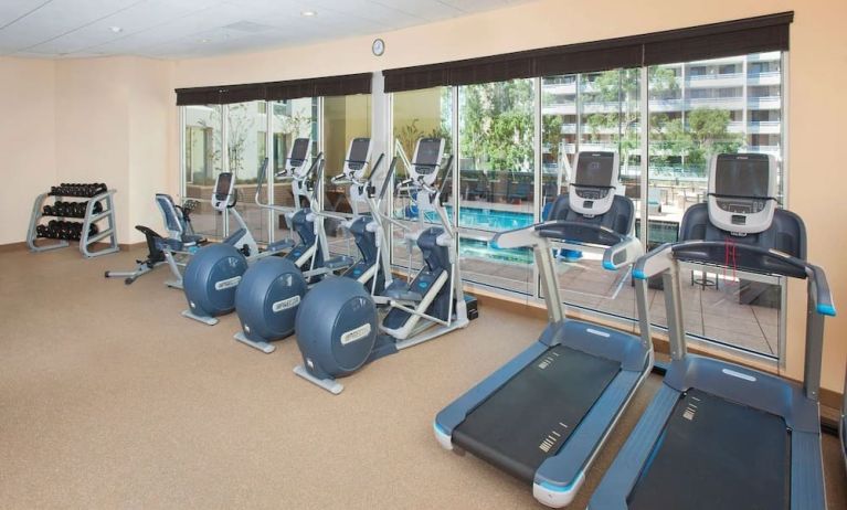 Fitness facility with a view of the pool at Hilton Garden Inn Burbank Downtown.