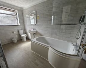 Guest bathroom with combined tub and shower at Little Foxes Hotel.