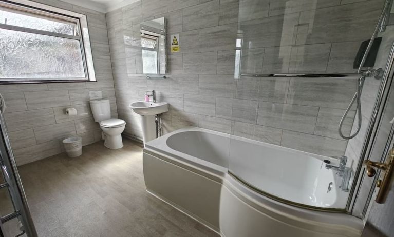 Guest bathroom with combined tub and shower at Little Foxes Hotel.