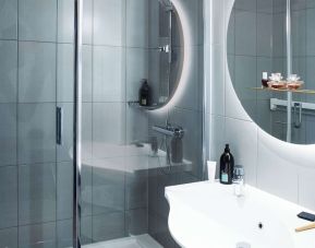 Private guest bathroom with shower and free toiletries at Adagio Aparthotel Edinburgh Royal Mile.
