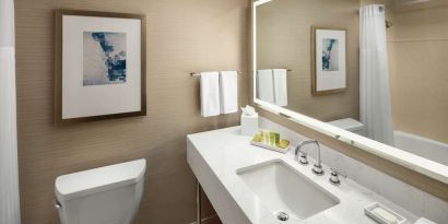 Guest bathroom with shower and tub at Hilton Boston Logan Airport.