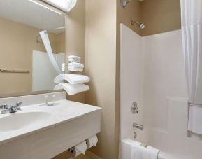 Guest bathroom with shower and tub at Coratel Inn & Suites By Jasper New Richmond.