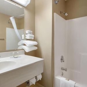 Guest bathroom with shower and tub at Coratel Inn & Suites By Jasper New Richmond.