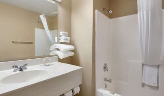 Guest bathroom with shower and tub at Coratel Inn & Suites By Jasper New Richmond.