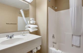 Guest bathroom with shower and tub at Coratel Inn & Suites By Jasper New Richmond.