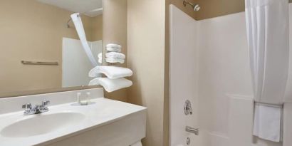 Guest bathroom with shower and tub at Coratel Inn & Suites By Jasper New Richmond.