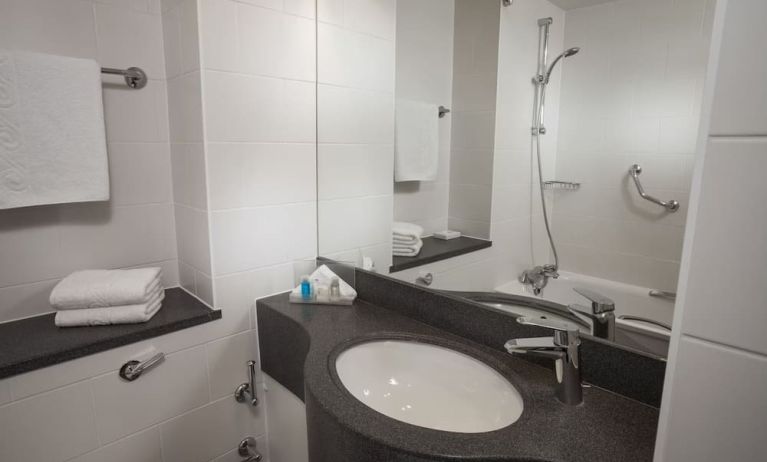 Private guest bathroom with comined shower and tub at Holiday Inn London - Heathrow M4J4.