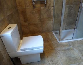 Guest bathroom with shower at Campbell Guest House Hotel.