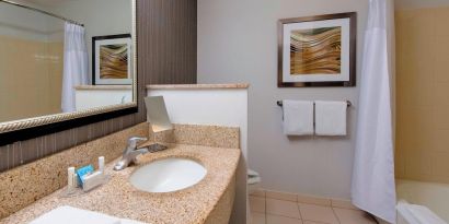 Guest bathroom with shower and tub at Courtyard By Marriott Montgomery Prattville.