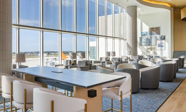 Ample seats with natural light perfect for coworking at Plaza Premium Lounge. Terminal C (MCO).