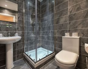 Guest bathroom with shower and free toiletries at The Bayswater Inn Hotel.