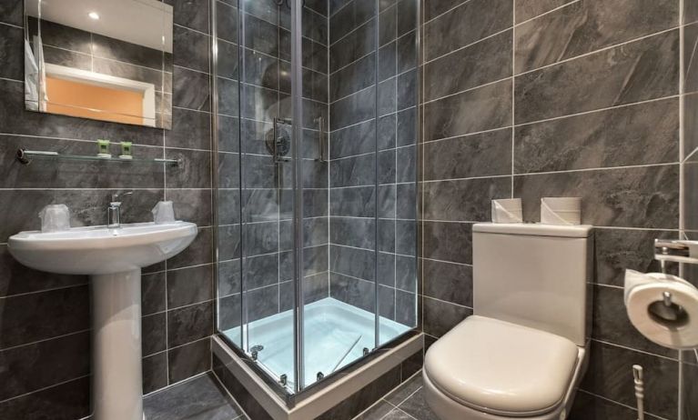 Guest bathroom with shower and free toiletries at The Bayswater Inn Hotel.