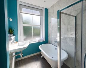 Private guest bathroom with shower and tub at The Lodge - Putney Hotel.