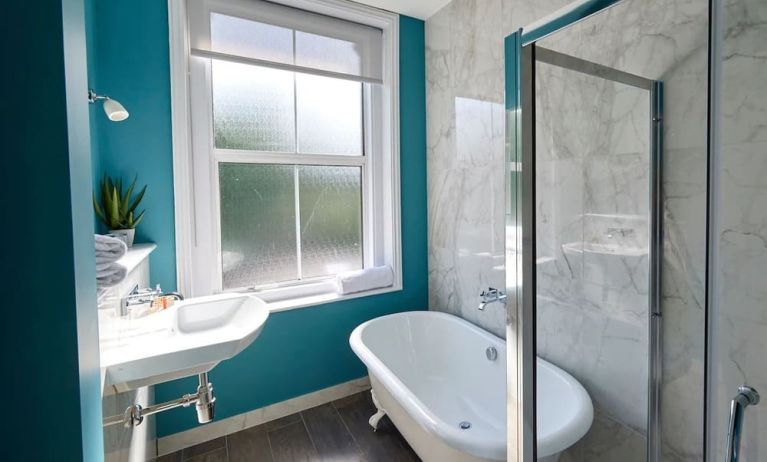 Private guest bathroom with shower and tub at The Lodge - Putney Hotel.