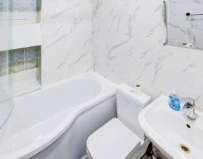 Private guest bathroom with tub and free toiletries at London Shelton Hotel.