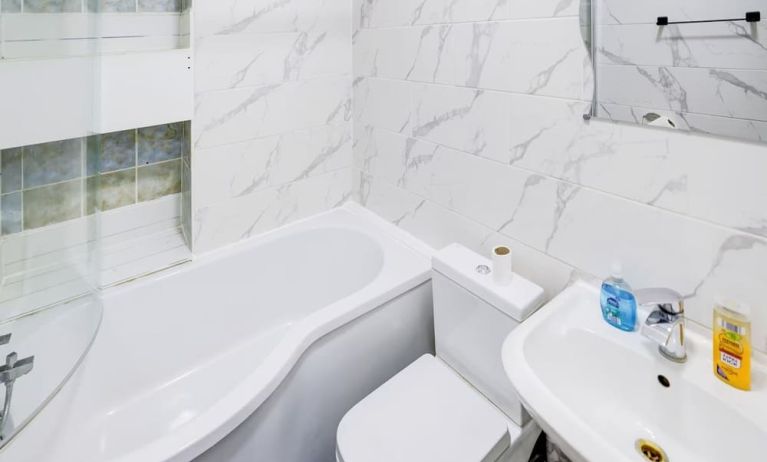 Private guest bathroom with tub and free toiletries at London Shelton Hotel.