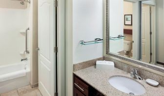 Guest bathroom with shower and tub at Residence Inn By Marriott Hattiesburg.