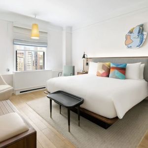 King bedroom with lounge area and natural light at The James New York, NoMad.