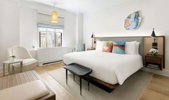 King bedroom with lounge area and natural light at The James New York, NoMad.