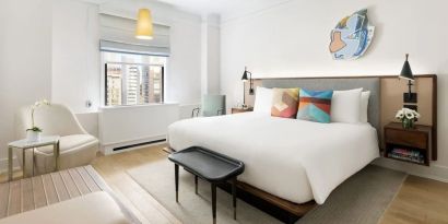 King bedroom with lounge area and natural light at The James New York, NoMad.