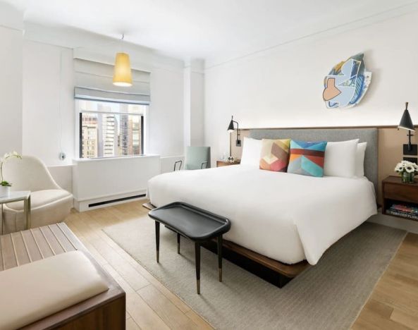 King bedroom with lounge area and natural light at The James New York, NoMad.