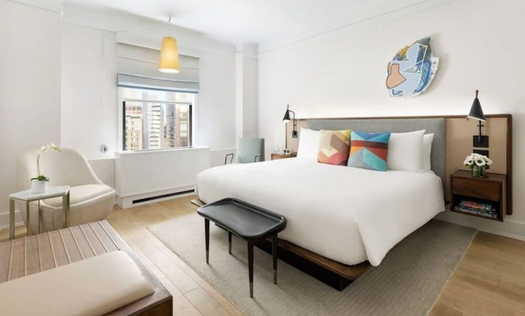 King bedroom with lounge area and natural light at The James New York, NoMad.