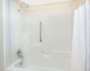 Guest bathroom with shower and tub at Blue Way Inn & Suites Wichita East.