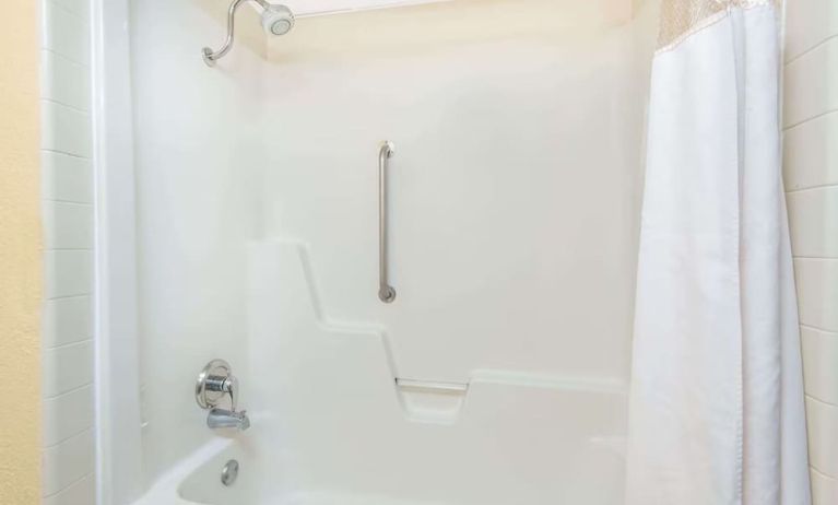 Guest bathroom with shower and tub at Blue Way Inn & Suites Wichita East.