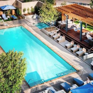 Refreshing outdoor pool surrounded by pool chairs at Hotel Nia, Autograph Collection.