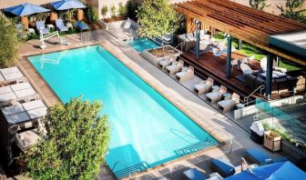 Refreshing outdoor pool surrounded by pool chairs at Hotel Nia, Autograph Collection.