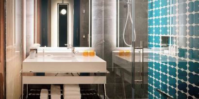 Guest bathroom with shower at Hotel Nia, Autograph Collection.