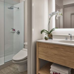 Guest bathroom with shower at Alohilani Resort Waikiki Beach.