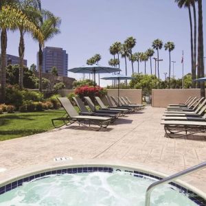 Outdoor pool with lounge chairs at Embassy Suites By Hilton San Diego-La Jolla.