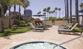 Outdoor pool with lounge chairs at Embassy Suites By Hilton San Diego-La Jolla.