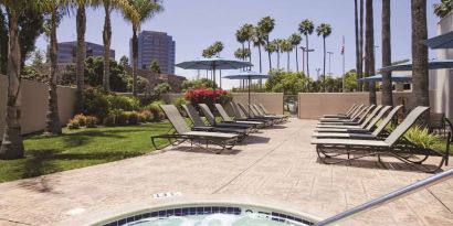 Outdoor pool with lounge chairs at Embassy Suites By Hilton San Diego-La Jolla.