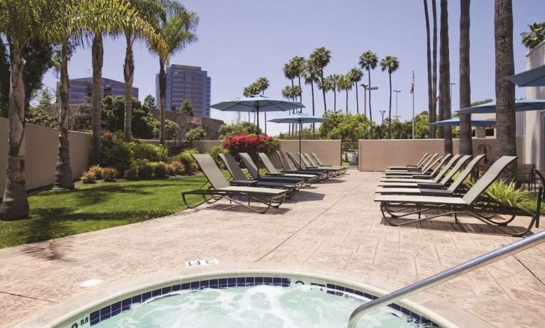 Outdoor pool with lounge chairs at Embassy Suites By Hilton San Diego-La Jolla.