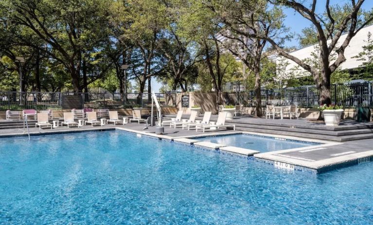 Refreshing outdoor pool surrounded by loungers at Hilton Dallas Lincoln Centre.