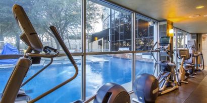 Fitness center overlooking the pool at Hilton Dallas Lincoln Centre.