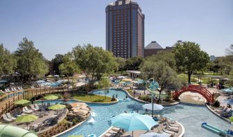 Lazy river, waterslide, and sun loungers available around the outdoor pool at Hilton Anatole.