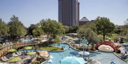 Lazy river, waterslide, and sun loungers available around the outdoor pool at Hilton Anatole.