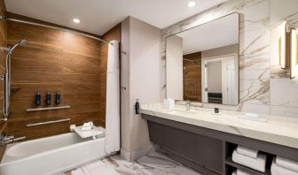 Private guest bathroom with tub at Hilton BNA Nashville Airport Terminal.
