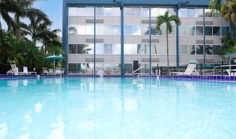 Relaxing outdoor pool with lounge area at EnVision Hotel Miami International Airport.