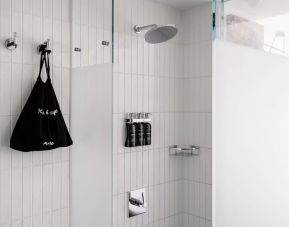 Private guest bathroom with shower and free toiletries at Arlo SoHo.