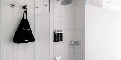 Private guest bathroom with shower and free toiletries at Arlo SoHo.